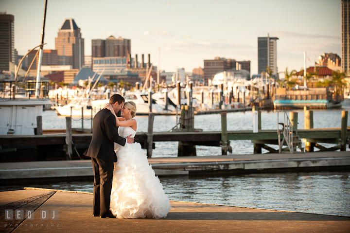 Bride and Groom hugging by the pier dock on the harbor with Baltimore City view. Baltimore Museum of Industry wedding photos by photographers of Leo Dj Photography. http://leodjphoto.com