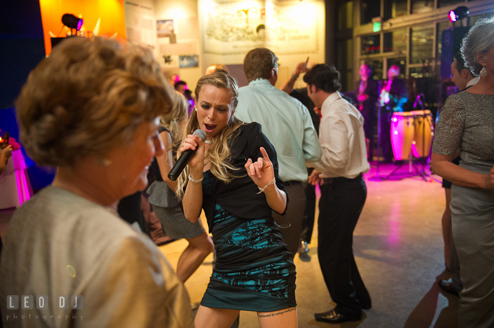 Singer girl from Spectrum band from Washington Talent Agency perfroming in between the crowds. Baltimore Museum of Industry wedding photos by photographers of Leo Dj Photography. http://leodjphoto.com