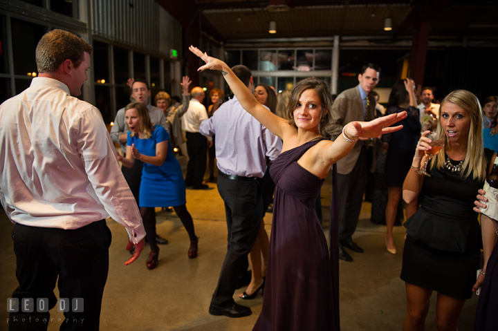 Bridesmaid stretching hands while dancing. Baltimore Museum of Industry wedding photos by photographers of Leo Dj Photography. http://leodjphoto.com