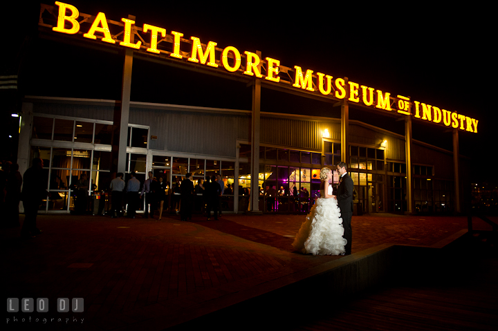 Bride and Groom posing in front of the BMI neon sign. Baltimore Museum of Industry wedding photos by photographers of Leo Dj Photography. http://leodjphoto.com