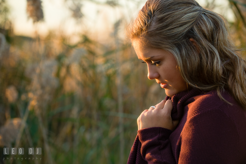Girl looking down while holding her sweaters' collar. Eastern Shore, Maryland, Queen Anne's County High School senior portrait session by photographer Leo Dj Photography. http://leodjphoto.com
