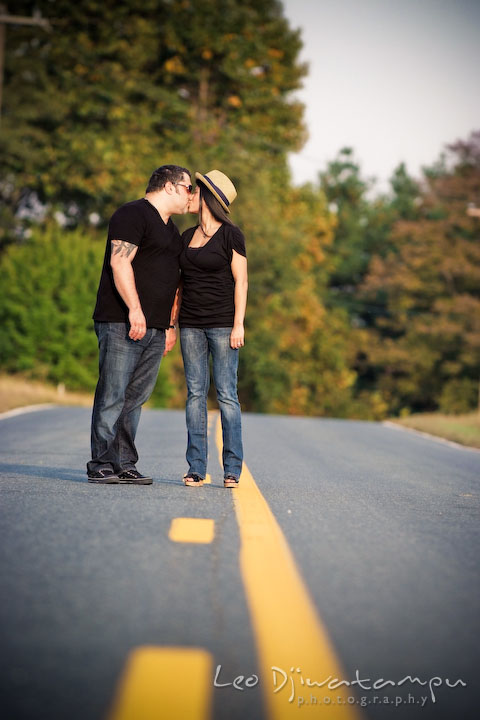 Engaged couple kissing in the middle of the road. Eastern Shore MD engagement pre-wedding photo session pier boat tattoo
