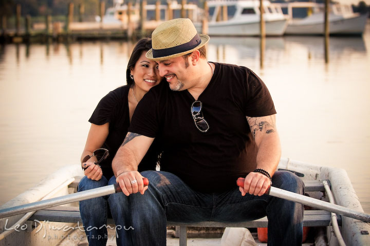 Engaged couple being close to each other on a boat. Eastern Shore MD engagement pre-wedding photo session pier boat tattoo