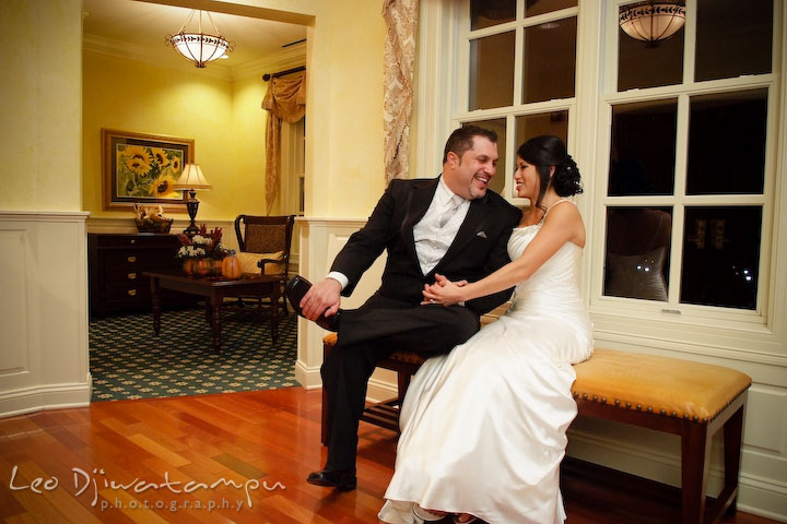 Bride and groom sitting and laughing on an antique bench. Baywood Clubhouse at Baywood Greens Wedding, St. Christophers Church Wedding, Kent Island, Eastern Shore Maryland