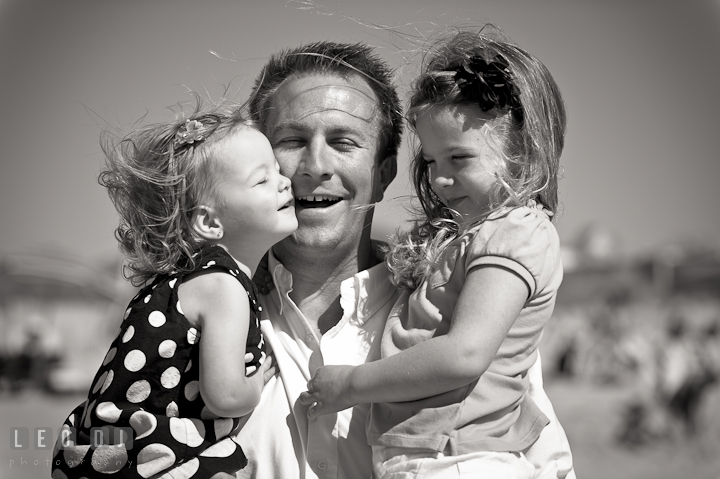 Father picking up his two girls and cuddling. Ocean City, Maryland Eastern Shore candid children and family lifestyle photo session by photographers of Leo Dj Photography. http://leodjphoto.com