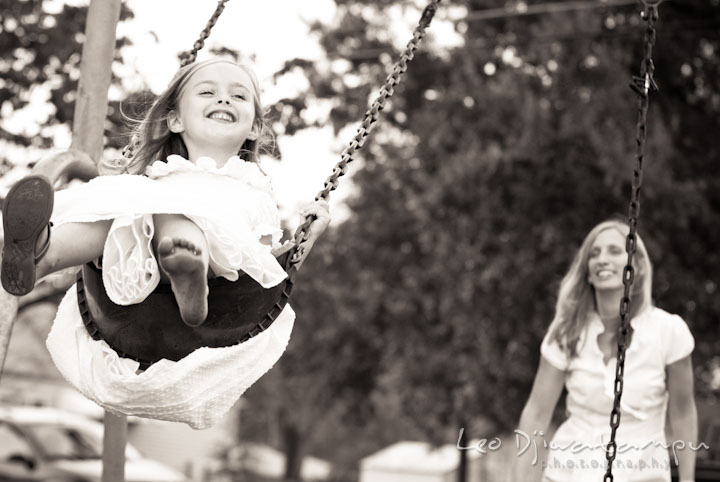 Girl giggling in a swing. Edgewater, Annapolis, Eastern Shore Maryland fun and candid children and family lifestyle photo session by photographers of Leo Dj Photography.