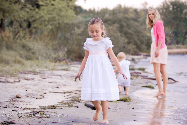 Girl walking on the beach, watched by Mom. Edgewater, Annapolis, Eastern Shore Maryland fun and candid children and family lifestyle photo session by photographers of Leo Dj Photography.