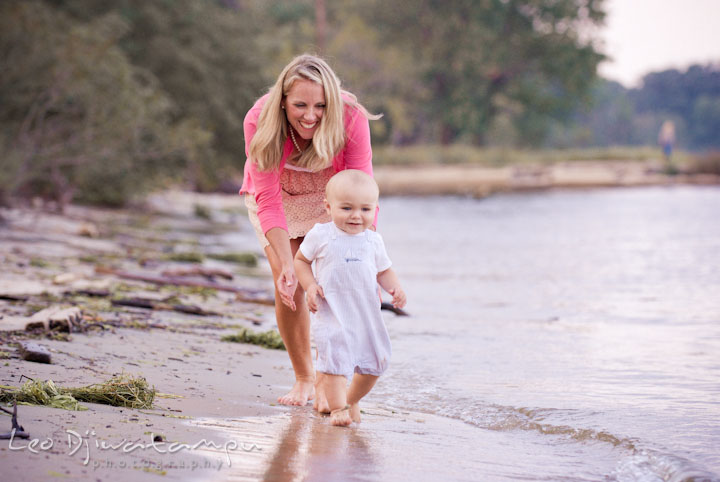 Toddler boy running, chased by Mom on the beach. Edgewater, Annapolis, Eastern Shore Maryland fun and candid children and family lifestyle photo session by photographers of Leo Dj Photography.