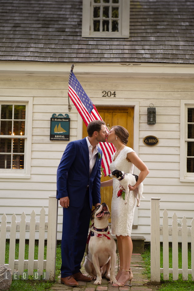 Bride and Groom kissing in front of their cottage with their dogs looking. The Oaks Waterfront Inn wedding, St Michaels, Eastern Shore, Maryland, by wedding photographers of Leo Dj Photography. http://leodjphoto.com