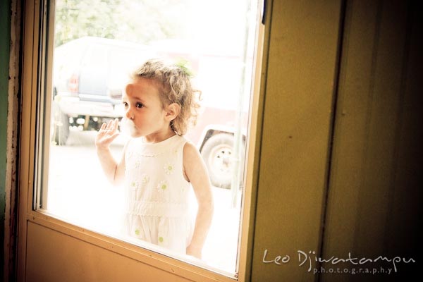 girl looking through door glass window. Children family reunion birthday photography Tilghman Island Annapolis Kent Island Eastern Shore MD