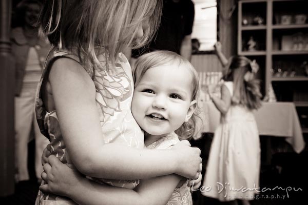 girl hugging her baby sister. Children family reunion birthday photography Tilghman Island Annapolis Kent Island Eastern Shore MD