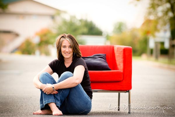 Girl with hair highlight, sitting on ground by red chair, smiling. Commercial work photography Annapolis Eastern Shore MD Washington DC