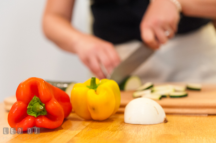 Engaged girl cutting vegetables for dinner. Engagement photo session at town home near Federal Hill Baltimore Maryland by wedding photographers of Leo Dj Photography (http://leodjphoto.com)