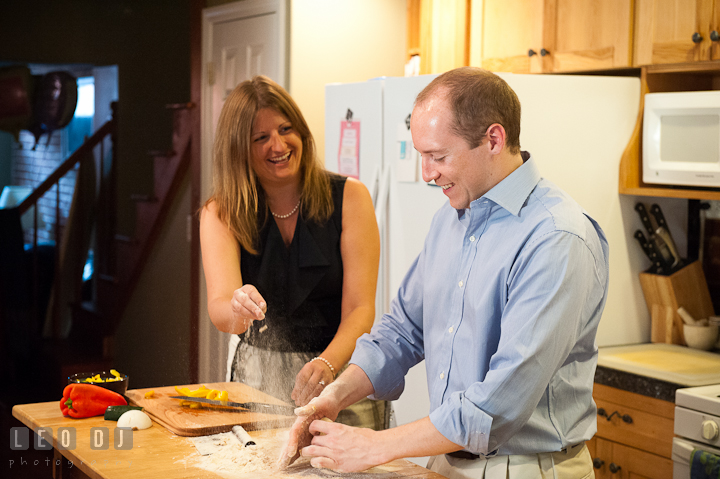 Engaged couple throwing flour at each other while cooking. Engagement photo session at town home near Federal Hill Baltimore Maryland by wedding photographers of Leo Dj Photography (http://leodjphoto.com)