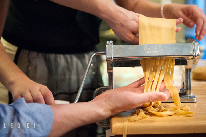 Engaged girl rolled the cutter for her fiancé to make linguine. Engagement photo session at town home near Federal Hill Baltimore Maryland by wedding photographers of Leo Dj Photography (http://leodjphoto.com)