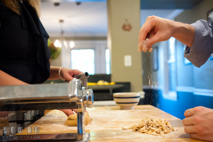 Engaged couple poured some flour on the finished linguine. Engagement photo session at town home near Federal Hill Baltimore Maryland by wedding photographers of Leo Dj Photography (http://leodjphoto.com)