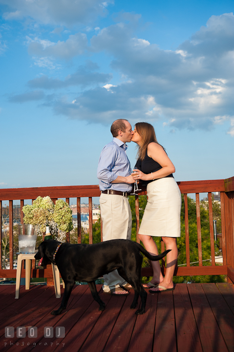 Engaged girl kissing with her fiancé at rooftop deck. Engagement photo session at town home near Federal Hill Baltimore Maryland by wedding photographers of Leo Dj Photography (http://leodjphoto.com)