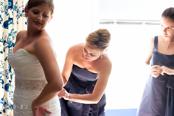 Maid of honor helping Bride buttoning the wedding dress. Getting ready and ceremony wedding photos at private estate at Preston, Easton, Eastern Shore, Maryland by photographers of Leo Dj Photography. http://leodjphoto.com