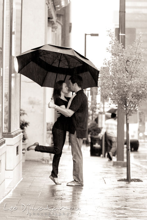 Engaged couple under the umbrella embracing each other. Tremont Plaza Hotel and Grand Historic Venue Baltimore Pre-wedding Engagement Photo Session by wedding photographers Leo Dj Photography