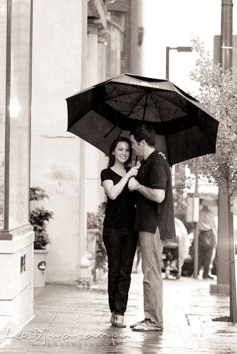 Engaged girl smiling with her fiancé under the rain and umbrella. Tremont Plaza Hotel and Grand Historic Venue Baltimore Pre-wedding Engagement Photo Session by wedding photographers Leo Dj Photography