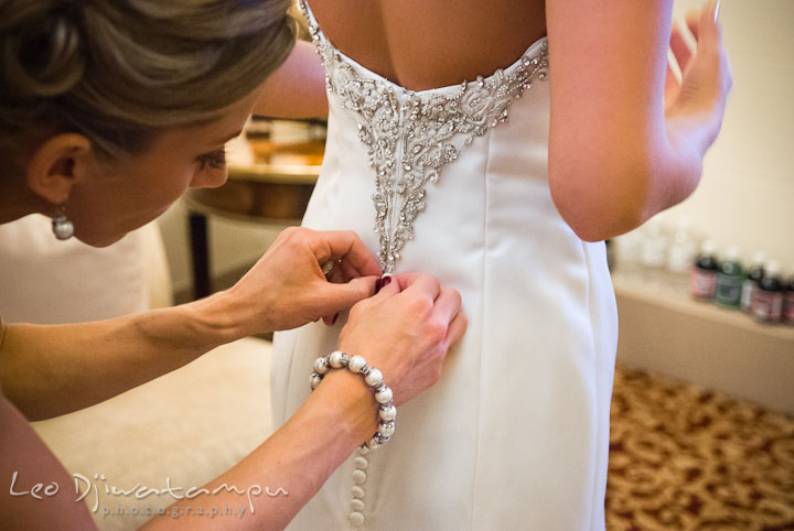 Maid of honor help bride buttoning up dress. Baltimore Maryland Tremont Plaza Hotel Grand Historic Venue wedding ceremony and reception photos, by photographers of Leo Dj Photography.