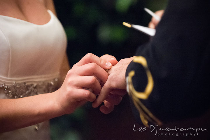 Bride sliding wedding band to Groom's finger. Baltimore Maryland Tremont Plaza Hotel Grand Historic Venue wedding ceremony and reception photos, by photographers of Leo Dj Photography.