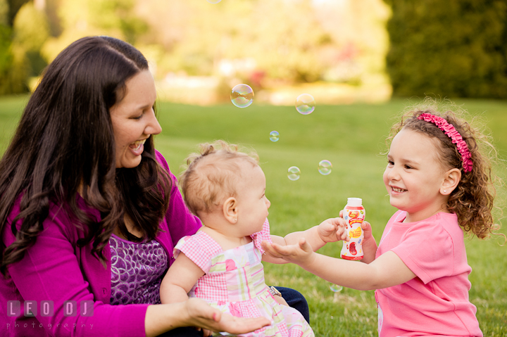 Mom, girl and baby sister playing bubbles. Washington DC, Silver Spring, Maryland candid children and family lifestyle photo session by photographers of Leo Dj Photography.