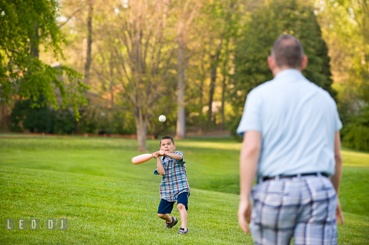 Boy playing baseball with Dad trying to bat the ball. Washington DC, Silver Spring, Maryland candid children and family lifestyle photo session by photographers of Leo Dj Photography.