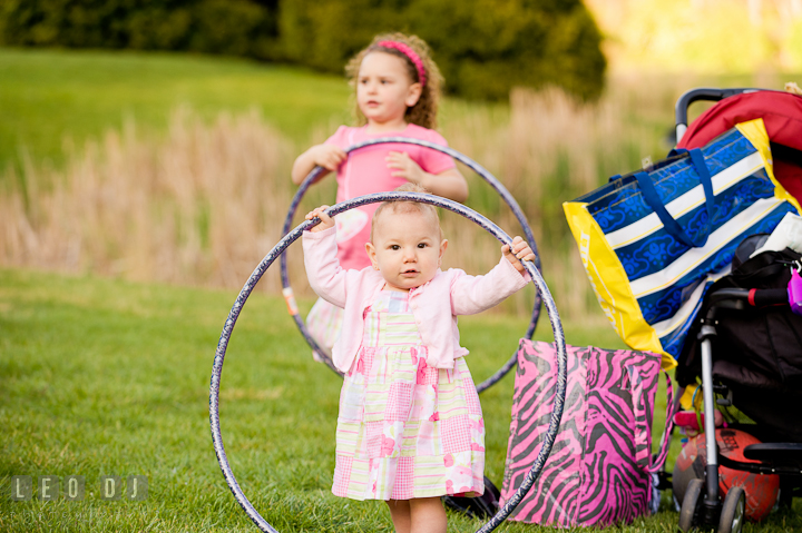 Little girl and her baby sister playing hula hoop. Washington DC, Silver Spring, Maryland candid children and family lifestyle photo session by photographers of Leo Dj Photography.