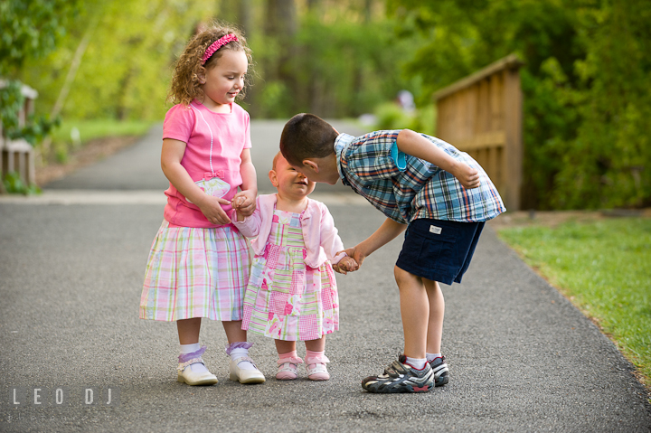 Brothers and sister holding hands, looking at each other. Washington DC, Silver Spring, Maryland candid children and family lifestyle photo session by photographers of Leo Dj Photography.