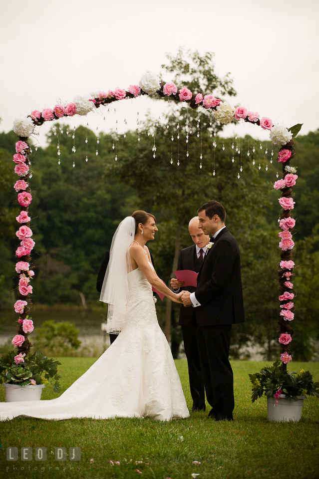 Bride and Groom holding hands during wedding ceremony. Aspen Wye River Conference Centers wedding at Queenstown Maryland, by wedding photographers of Leo Dj Photography. http://leodjphoto.com