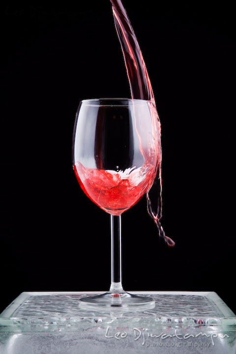 Pouring wine in wine glass with some spill. Lighting Essentials Workshops - Baltimore with Don Giannatti