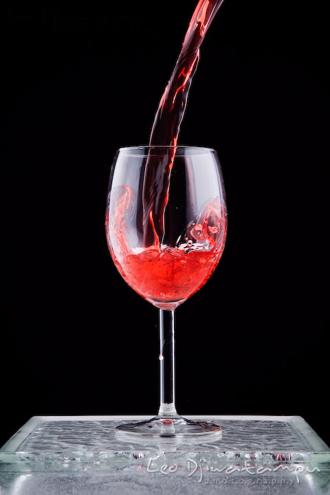 Pouring wine into a wine glass with some splash inside. Lighting Essentials Workshops - Baltimore with Don Giannatti