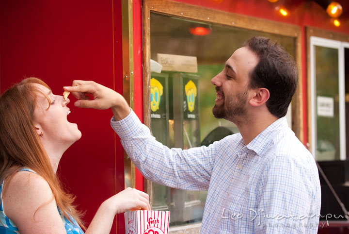 Engaged guy teasing his fiancée with a pop-corn. Washington DC National Zoo pre-wedding engagement session by Leo Dj Photography