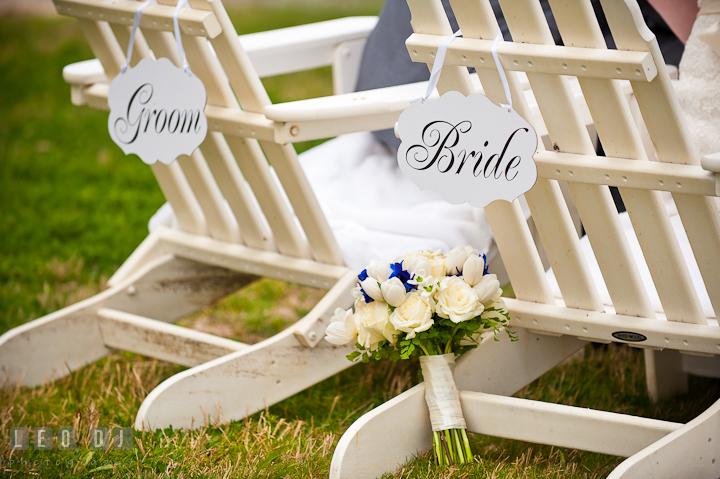 Wedding floral bouquet by adirondack chairs with Bride and Groom signs. Harbourtowne Golf Resort wedding photos at St. Michaels, Eastern Shore, Maryland by photographers of Leo Dj Photography.