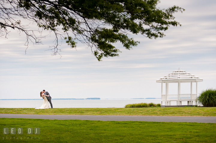 Bride and Groom doing the dip by a gazebo, by the water on the bay. Harbourtowne Golf Resort wedding photos at St. Michaels, Eastern Shore, Maryland by photographers of Leo Dj Photography.