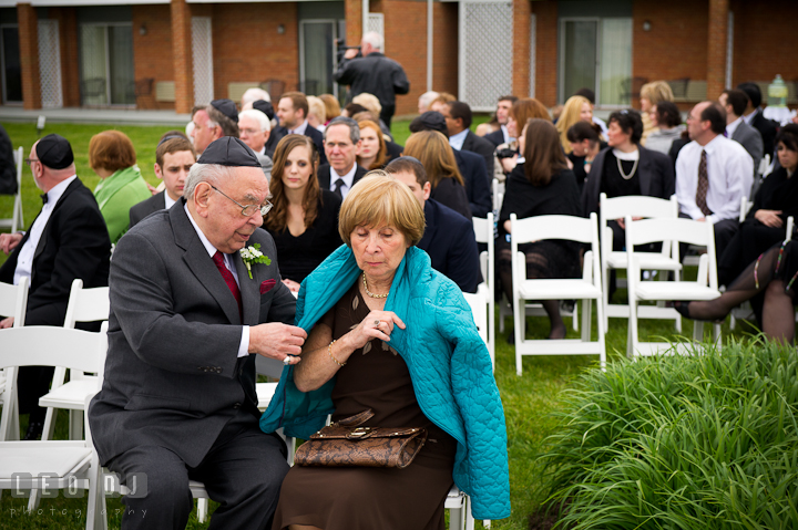Grandfather putting jacket on grandmother. Harbourtowne Golf Resort wedding photos at St. Michaels, Eastern Shore, Maryland by photographers of Leo Dj Photography.
