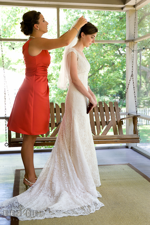 Matron of honor putting on veil on Bride. Saint John the Evangelist church wedding ceremony photos at Severna Park, Maryland by photographers of Leo Dj Photography. http://leodjphoto.com