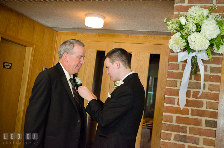 Groom helping his Father put on the boutonniere. Saint John the Evangelist church wedding ceremony photos at Severna Park, Maryland by photographers of Leo Dj Photography. http://leodjphoto.com