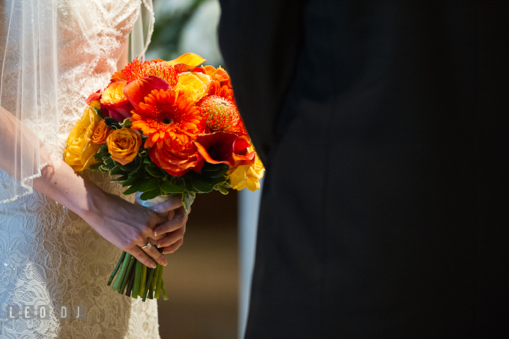 Bride holding her beautiful orange floral bouquet. Saint John the Evangelist church wedding ceremony photos at Severna Park, Maryland by photographers of Leo Dj Photography. http://leodjphoto.com