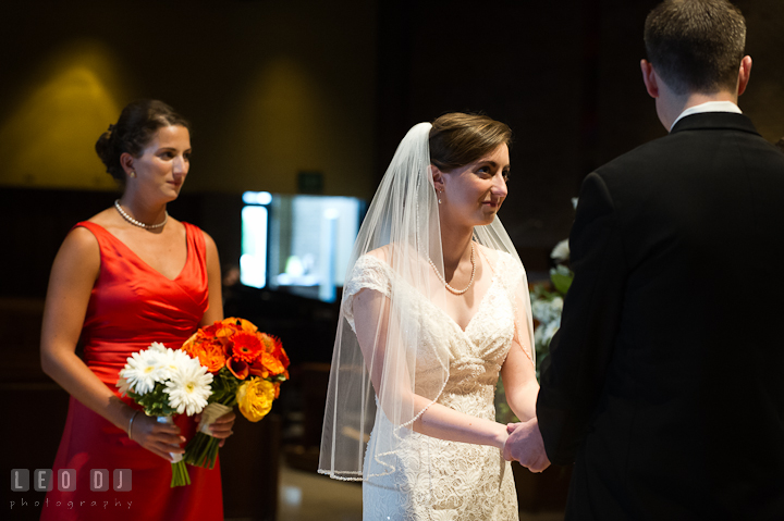 Bride holding Groom's hands and looking at him. Saint John the Evangelist church wedding ceremony photos at Severna Park, Maryland by photographers of Leo Dj Photography. http://leodjphoto.com