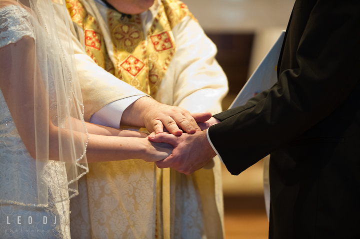 The priest, Father Jim Proffitt, blessing the Bride and Groom. Saint John the Evangelist church wedding ceremony photos at Severna Park, Maryland by photographers of Leo Dj Photography. http://leodjphoto.com