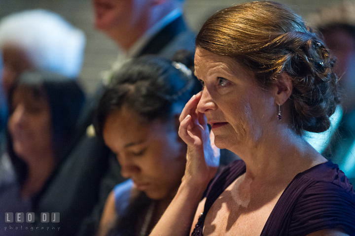 Mother of Groom wiping off tears from her eyes. Saint John the Evangelist church wedding ceremony photos at Severna Park, Maryland by photographers of Leo Dj Photography. http://leodjphoto.com