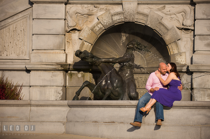 Engaged girl kissing her fiancé by a water fountain by the Capitol Hill. Washington DC pre-wedding engagement photo session, by wedding photographers of Leo Dj Photography. http://leodjphoto.com