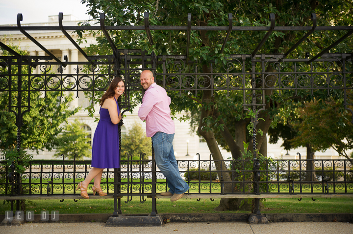 Engaged couple holding on antique bench poles by the Capitol Hill. Washington DC pre-wedding engagement photo session, by wedding photographers of Leo Dj Photography. http://leodjphoto.com