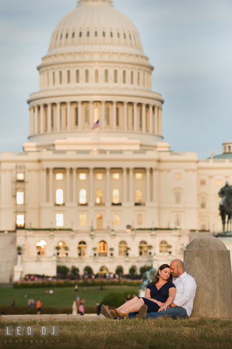 Engaged couple sitting on the ground and cuddling in front of the Capitol Hill. Washington DC pre-wedding engagement photo session, by wedding photographers of Leo Dj Photography. http://leodjphoto.com