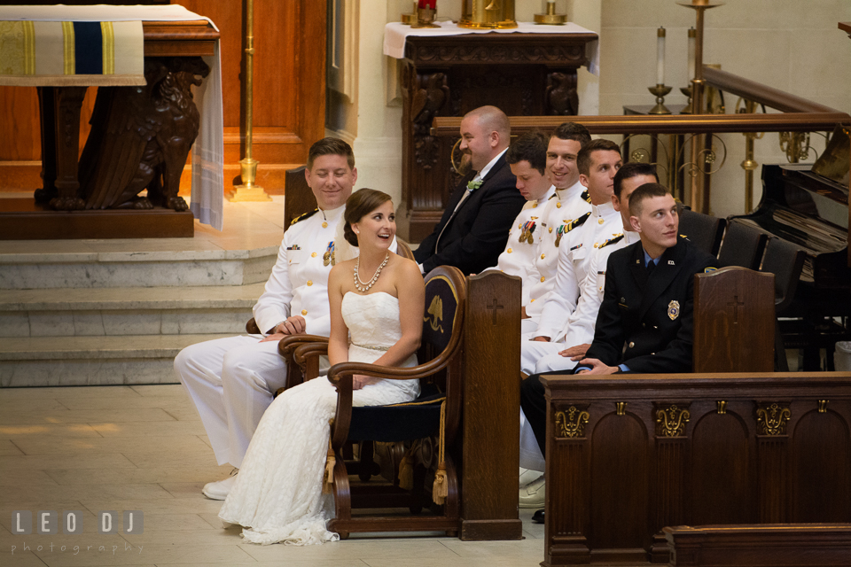 Bride and Groom during the ceremony smiling listening to the Priest's speech. USNA, US Naval Academy military wedding at Annapolis Maryland, by wedding photographers of Leo Dj Photography. http://leodjphoto.com