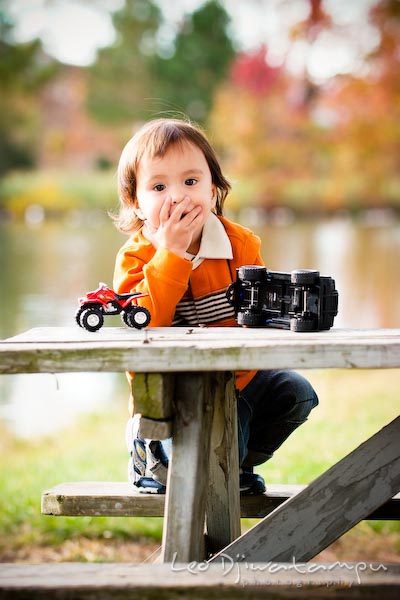 boy in orange shirt covering mouth, fall colored trees. Commercial comp card photograper Kent Island Annapolis MD Washington DC