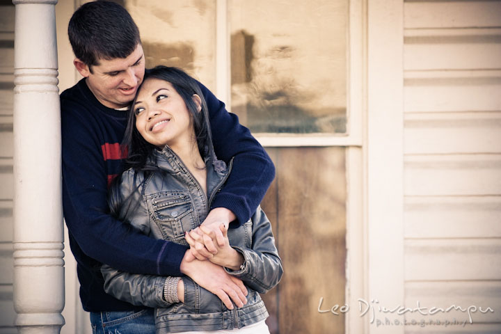 Engaged guy hugging his fiancée from behind. City or urban setting pre-wedding or engagement photo session at Annapolis, by Annapolis wedding photographer, Leo Dj Photography.