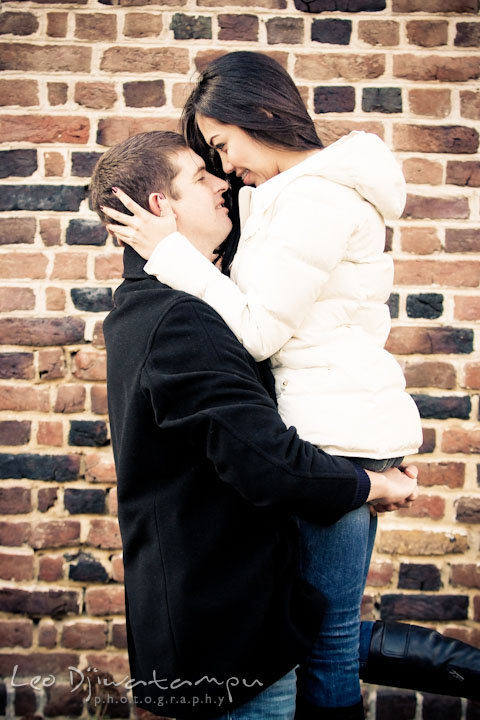 Engaged guy lifted up his fiancée, and both looking at each other, smiling. City or urban setting pre-wedding or engagement photo session at Annapolis, by Annapolis wedding photographer, Leo Dj Photography.